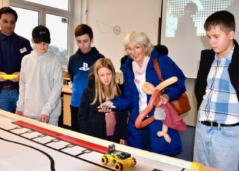 60 Jahre Max-Planck-Realschule: Das Funkfahrzeug der Robotik-AG hat es Josephine (Vierte von links) angetan: Mit ihrer Oma Edith (Zweite von rechts), Realschülerin der ersten Jahre, hat sie fast alle Mitmachangebote des Aktionsnachmittags ausprobiert. Foto: Gerd Markowetz